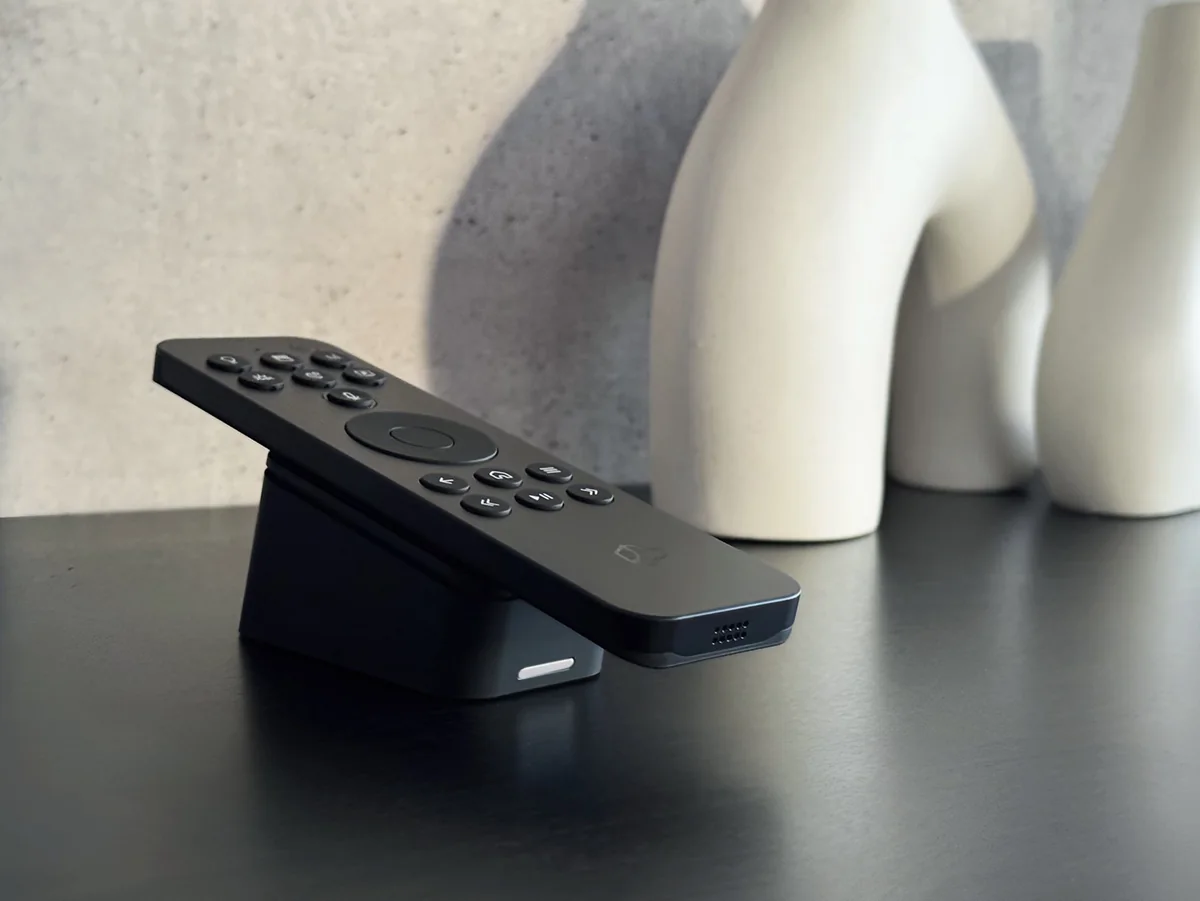 The Josh Edge remote resting in its charging dock on a dark table